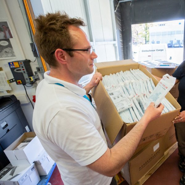 Michael Fanselow nimmt im Zentrallager des Uniklinikums Leipzig die Masken aus China von der Firma Cretschmar MesseCargo entgegen, die die insgesamt 10 Kartons vom Flughafen an die Klinik transportiert hat. Foto: Stefan Straube, Universitätsklinikum Leipzig