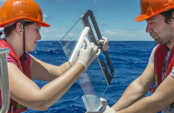 Zur Probenahme wird eine Glasplatte ins Wasser getaucht und anschließend wieder vorsichtig aus dem Wasser gezogen. Dabei bleibt der 200 Mikrometer dünne Oberflächenfilm am Glas haften und wird anschließend abgekratzt. Foto: Hartwig Deneke/TROPOS